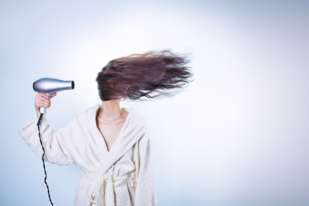 fan and air circulator pointed at drying duvet indoors