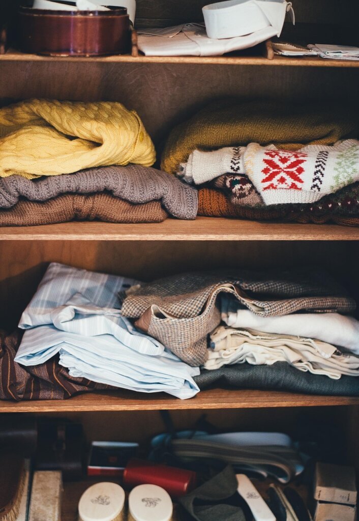 organized wardrobe with hanging clothes and folded clothes in drawers below