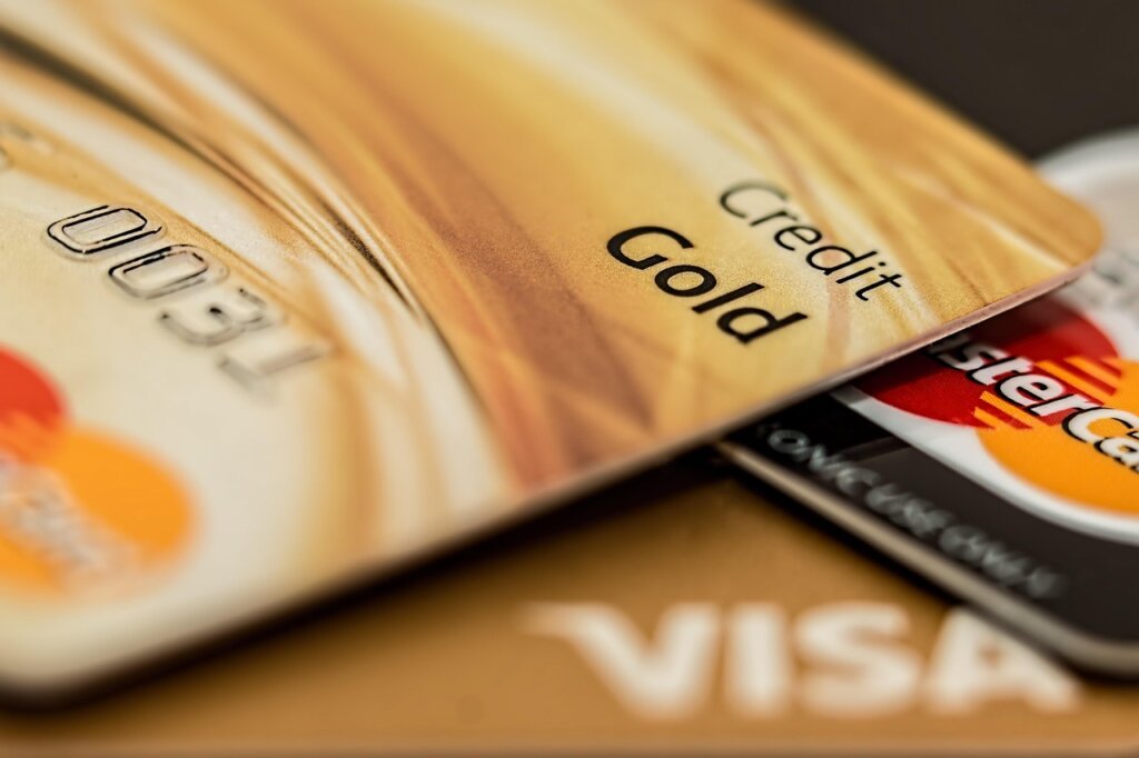 plastic credit card scraping off sticker residue from glass surface at angle