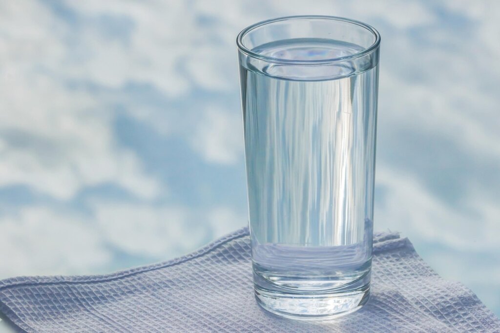 glass tumbler soaking in warm water with baking soda