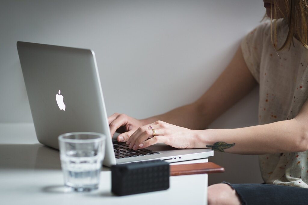 small business owner at desk researching natural product ingredients on laptop in summer