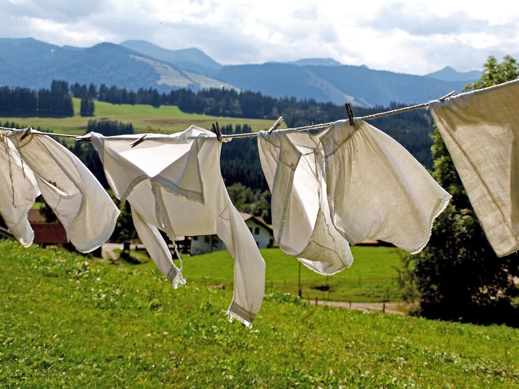 fan blowing upward toward hanging laundry indoors