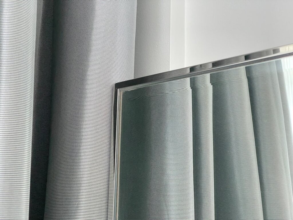 different types of window screen mesh rolls displayed side by side including standard nylon and stainless steel