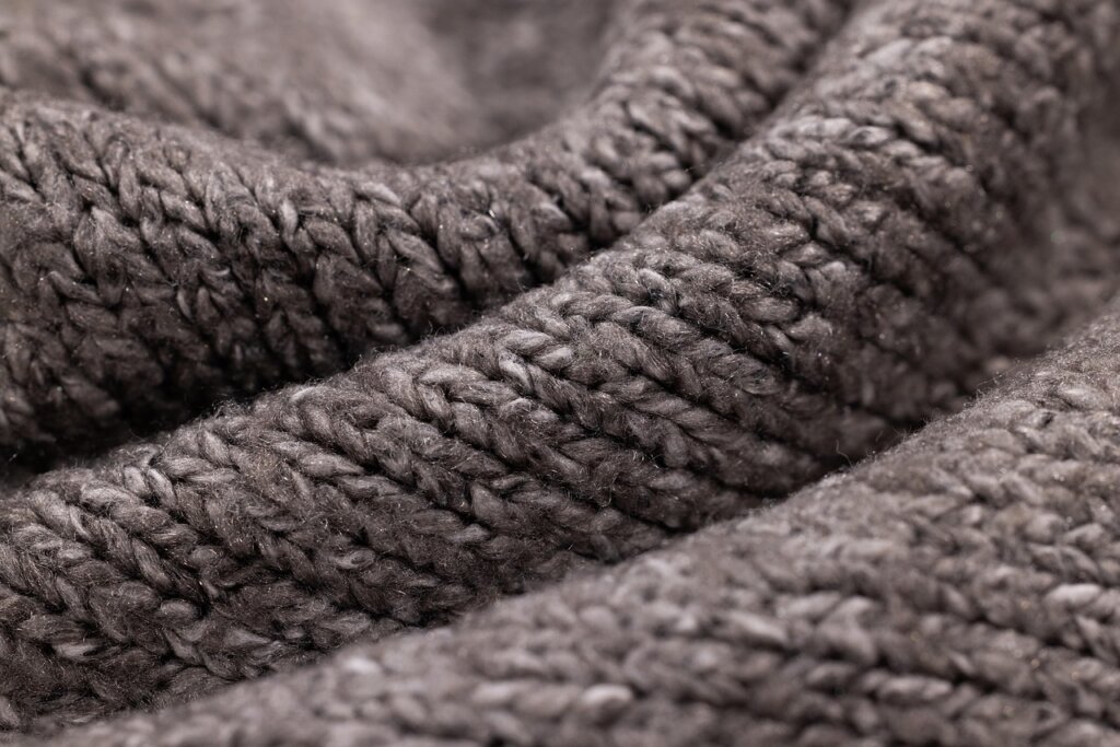 electric fabric lint remover on gray wool sweater