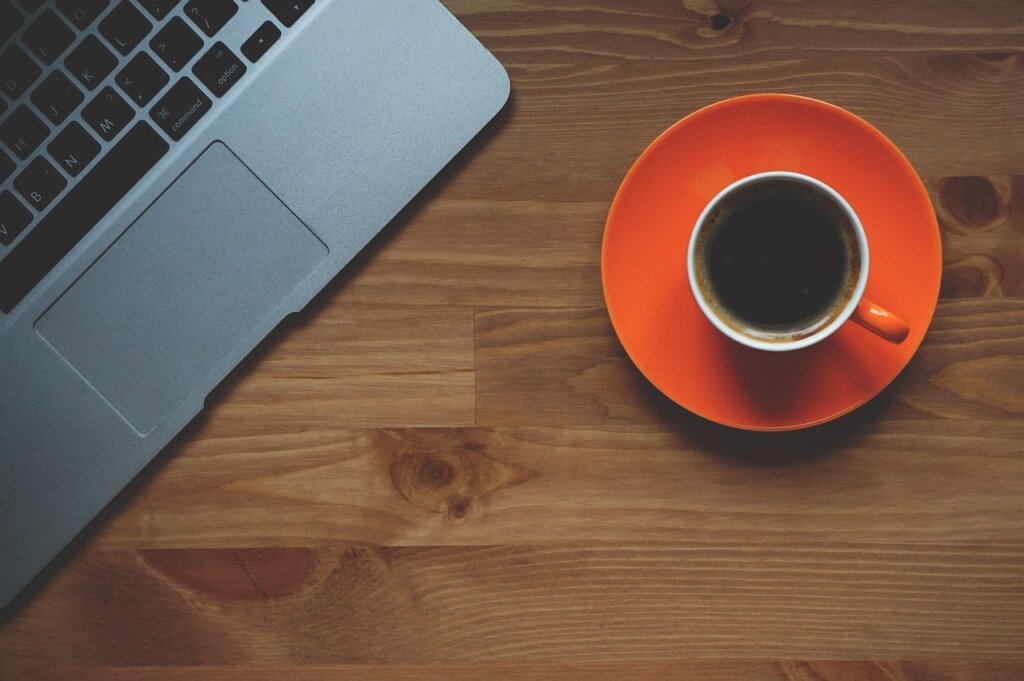 tired middle aged man at desk with coffee cup