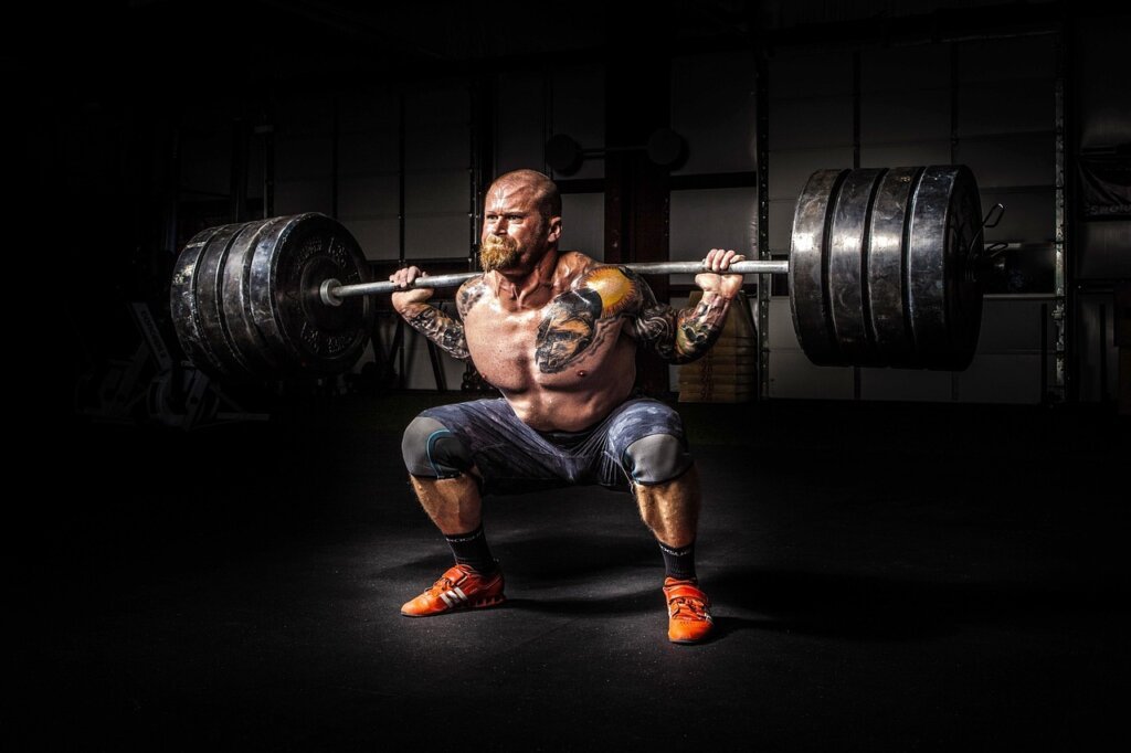 muscular man performing heavy barbell squat in a weight room with focused expression